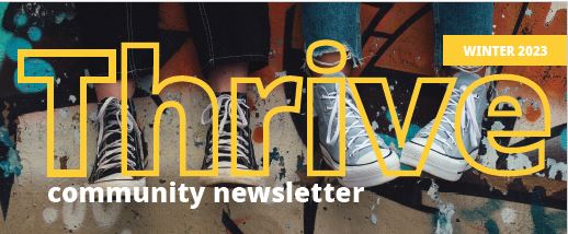 Two people wearing sneakers sit in front of a colorful graffiti wall. The word Thrive in large yellow text overlays the image, with community newsletter and Winter 2023 also displayed.